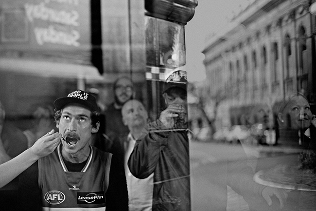 Male football fan eating meal and watching television at pub